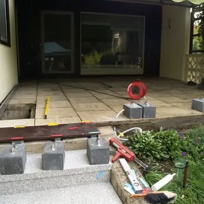 Terrassenfläche auf Stelzlagern vor der Sanierung: alte Platten, Unterbau während des Umbaus offen