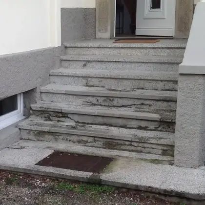 Sechsstufige Außentreppe vor der Sanierung: ausgebrochene und mehrfach geflickte Betonstufen