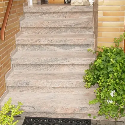 Eingangstreppe am Klinkerhaus nach der Sanierung: cremefarbener, geäderter Naturstein – InnoStone Treppensanierung