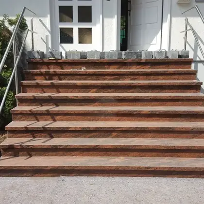 Gartentreppe, sieben Stufen nach der Sanierung: rotbrauner Granit mit durchgehender Trittkante – InnoStone Treppensanierung