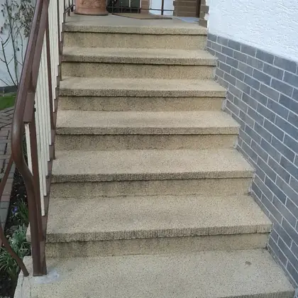 Außentreppe an der Klinkerwand vor der Sanierung: abgetretener Beton mit abgerundeten Kanten