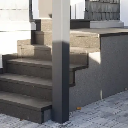 Stark geschädigte Betontreppe nach der Sanierung: Anthrazit-Granit inklusive neu verkleideter Wange – InnoStone Treppensanierung