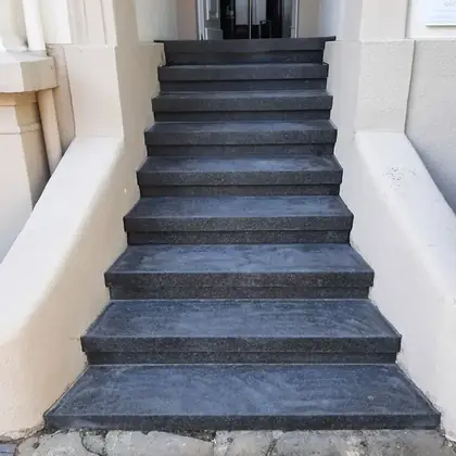 Außentreppe mit geschwungenen Wangen nach der Sanierung: durchgehende Anthrazit-Stufen – InnoStone Treppensanierung