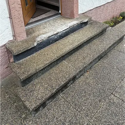 Dreistufiger Hauseingang vor der Sanierung: Waschbeton mit dunkler Trittkante