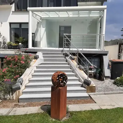 Große Terrassentreppe am Wohnhaus nach der Sanierung: breite Stufen in hellgrauem Granit – InnoStone Treppensanierung