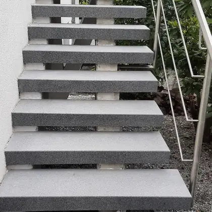 Freitragende Stufen am Kiesbeet nach der Sanierung: Anthrazit-Granit auf bestehender Unterkonstruktion – InnoStone Treppensanierung