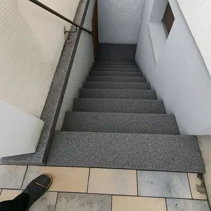 Enger Kellerabgang nach der Sanierung: grauer Granit inklusive seitlicher Abdeckung – InnoStone Treppensanierung