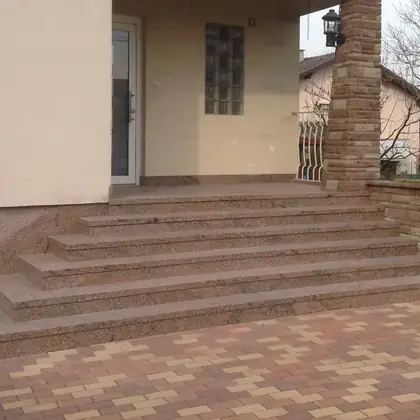 L-förmiger Hauseingang nach der Sanierung: beige-rosé Granit über Eck geführt – InnoStone Treppensanierung