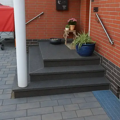 L-Podest am Klinkerhaus nach der Sanierung: Anthrazit-Granit über Eck, Podest und Stufe – InnoStone Treppensanierung