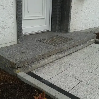 Eingangspodest mit Stufe vor der Sanierung: gerissene Betonkante, abgesackter Rand