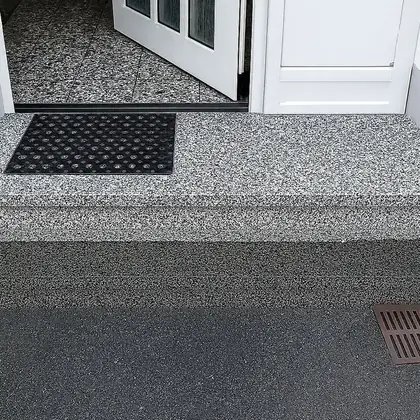 Schmales Eingangspodest nach der Sanierung: hellgrauer, gesprenkelter Granit – InnoStone Treppensanierung