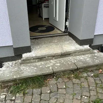 Hauseingang in Rimpar vor der Sanierung: abgebröckelte, ausgebrochene Betonstufe