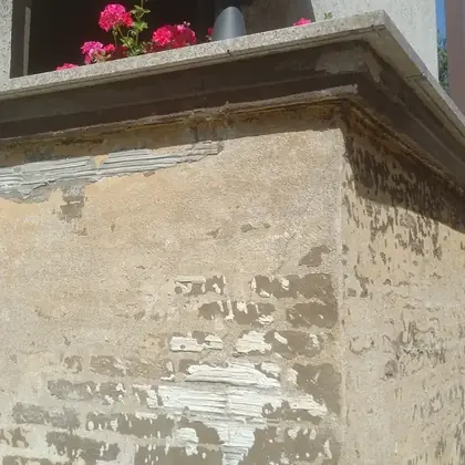 Treppenwange und Mauerkopf vor der Sanierung: abgeplatzter Putz, freiliegendes Mauerwerk